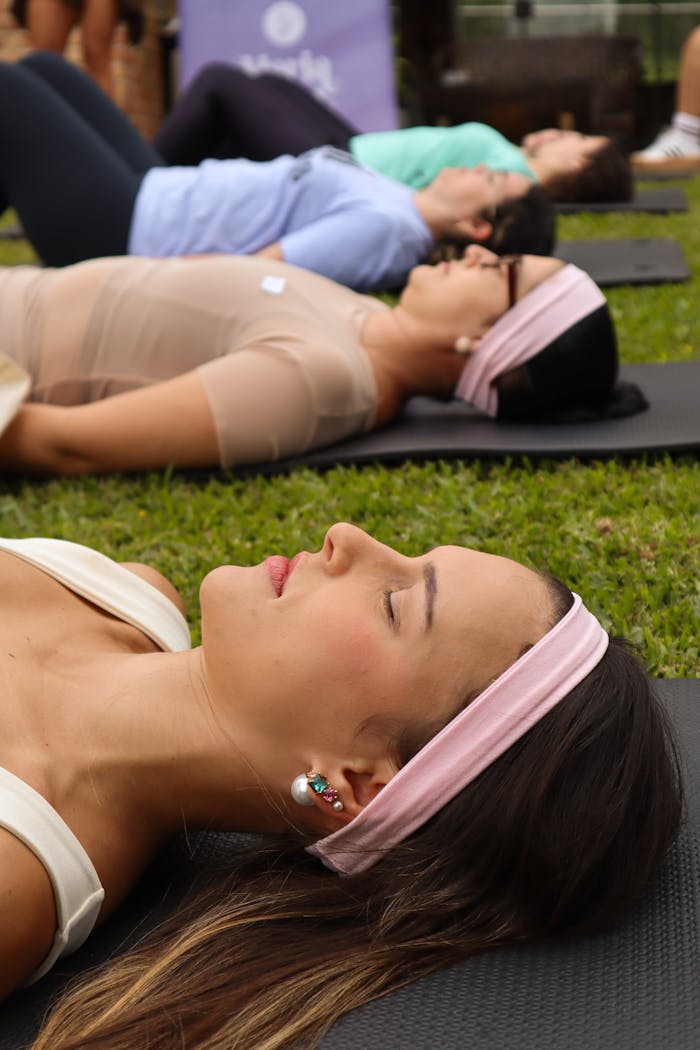 About A serene outdoor yoga class with adults meditating on yoga mats. Perfect relaxation concept.